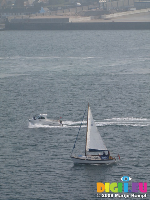 SX03423 Small motorboat and sailboat in Milford Haven